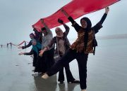 Mahasiswa Bersama Masyarakat Kibarkan Bendera Merah Putih Raksasa 580 Meter di Pantai Kapoiala